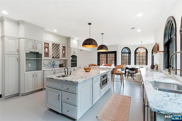 a living room with couches a large mirror and a large window with wooden floor