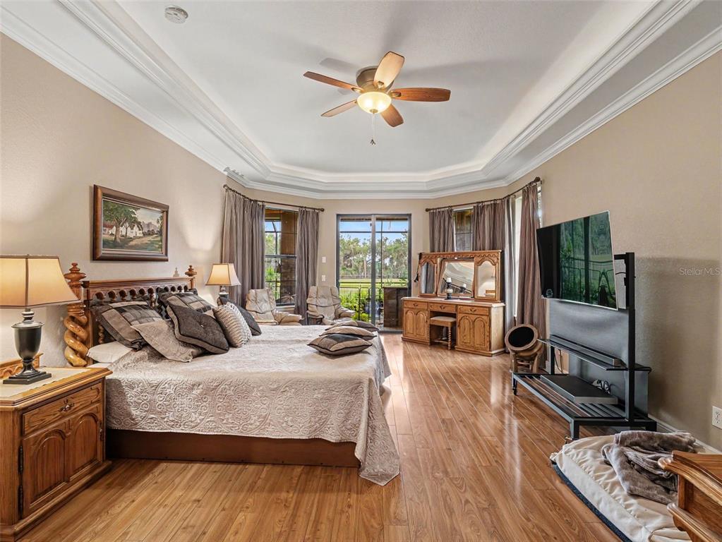339 Corbett Road Lithia, FL 33547 - Photo 21 of 38 a bedroom with a large bed a flat tv screen and a fireplace
