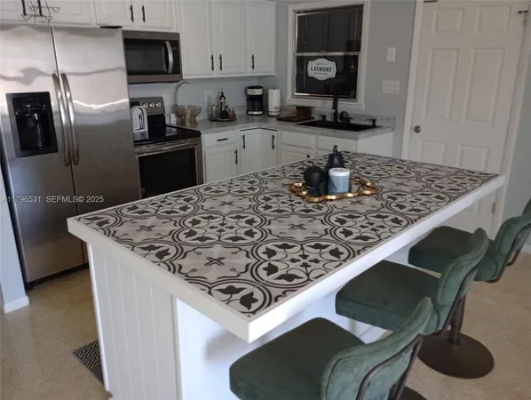 a kitchen with kitchen island granite countertop a sink stove and refrigerator