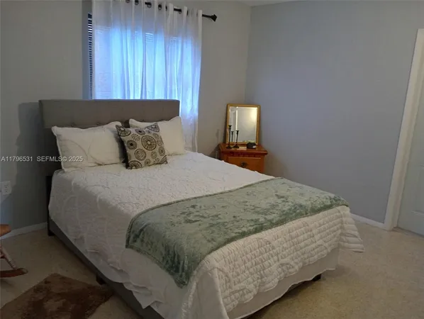 a bed sitting in a bedroom next to a wooden cabinet