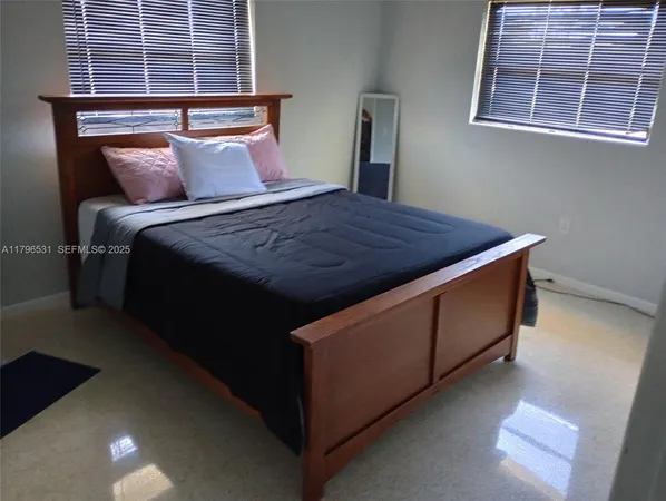 a bed sitting in a bedroom next to a window