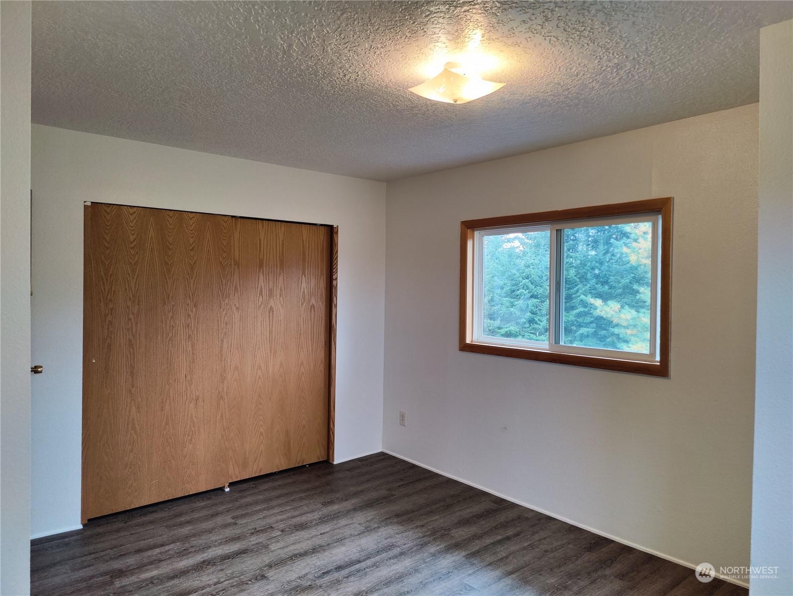 126 Reinseth Road Winlock, WA 98596 - Photo 18 of 33 a view of an empty room with wooden floor and a window
