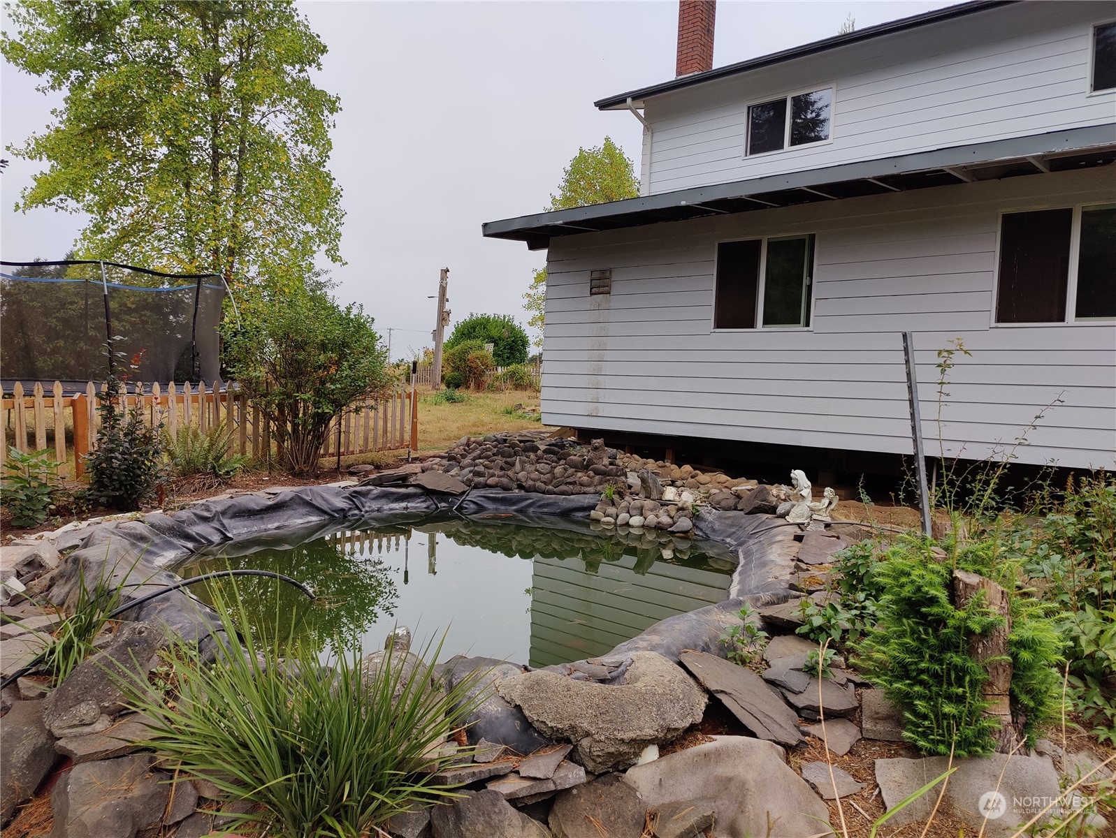 126 Reinseth Road Winlock, WA 98596 - Photo 28 of 33 a backyard of a house with lake view and a potted plant