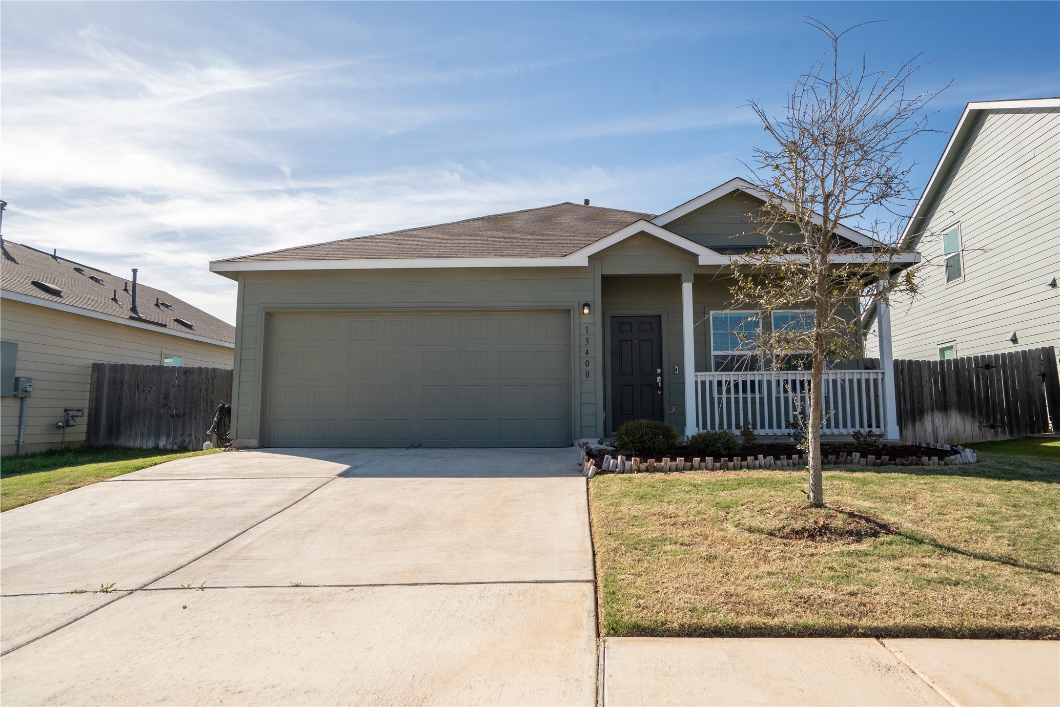 13400 Banquete Street Elgin, TX 78621 - Photo 1 of 29 Ranch-style home with a garage, driveway, a porch, and roof with shingles