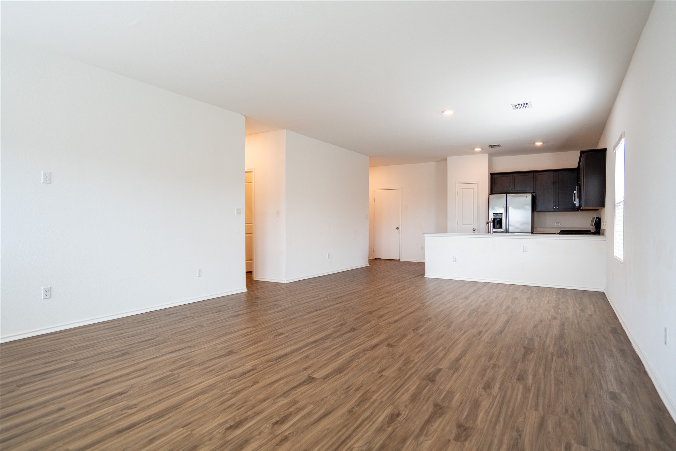 13400 Banquete Street Elgin, TX 78621 - Photo 10 of 29 Unfurnished living room featuring dark wood finished floors and recessed lighting