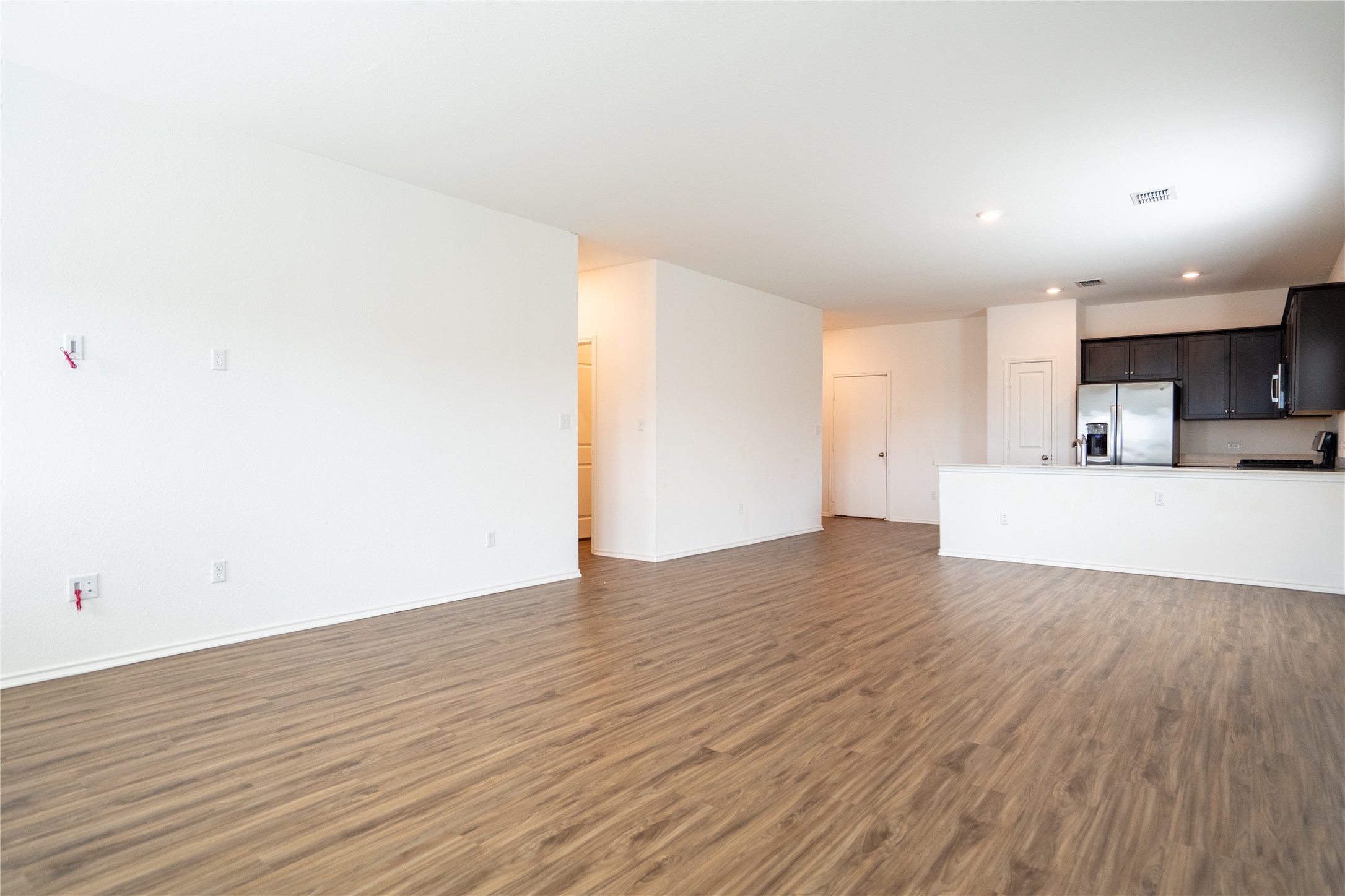 13400 Banquete Street Elgin, TX 78621 - Photo 13 of 29 Unfurnished living room featuring dark wood-style floors and recessed lighting