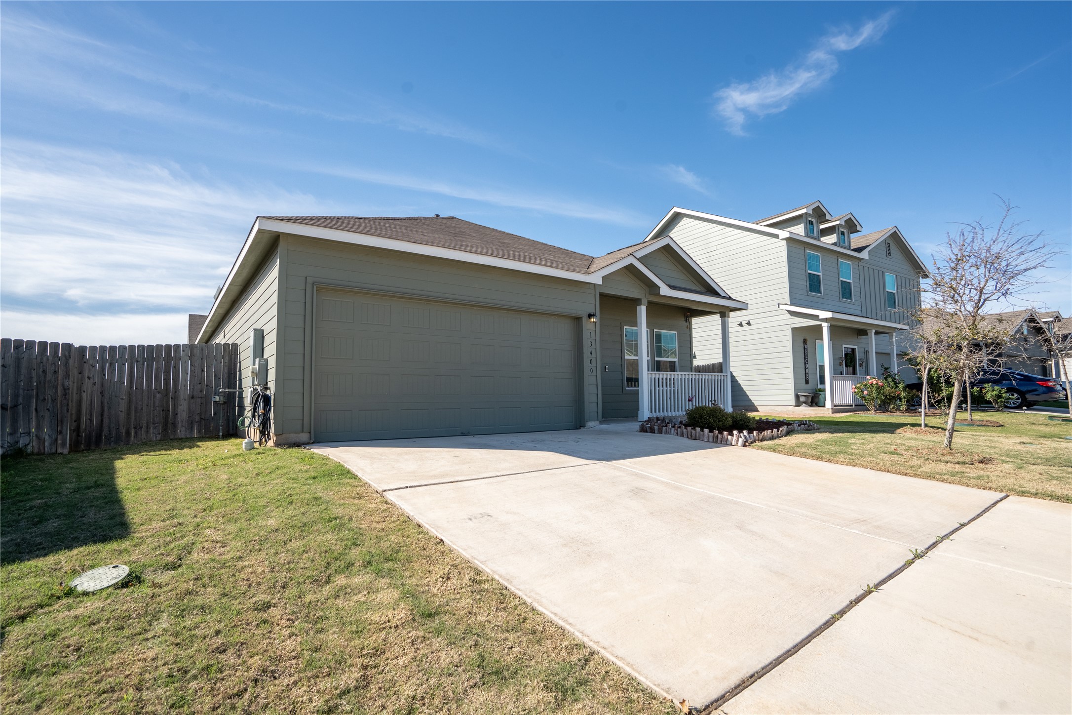 13400 Banquete Street Elgin, TX 78621 - Photo 2 of 29 Traditional-style house featuring an attached garage, concrete driveway, and covered porch