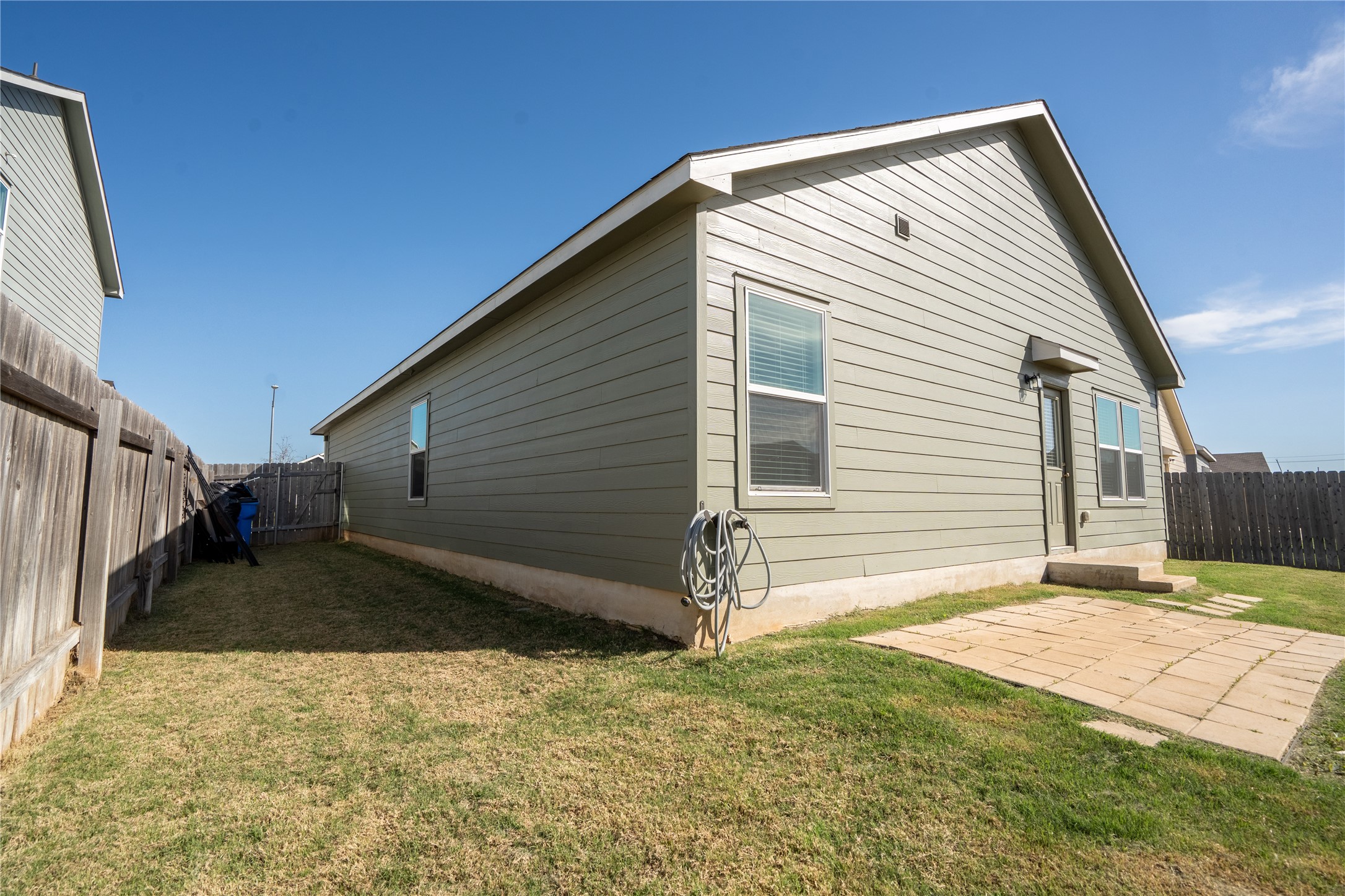 13400 Banquete Street Elgin, TX 78621 - Photo 28 of 29 Back of property featuring a fenced backyard and a patio area
