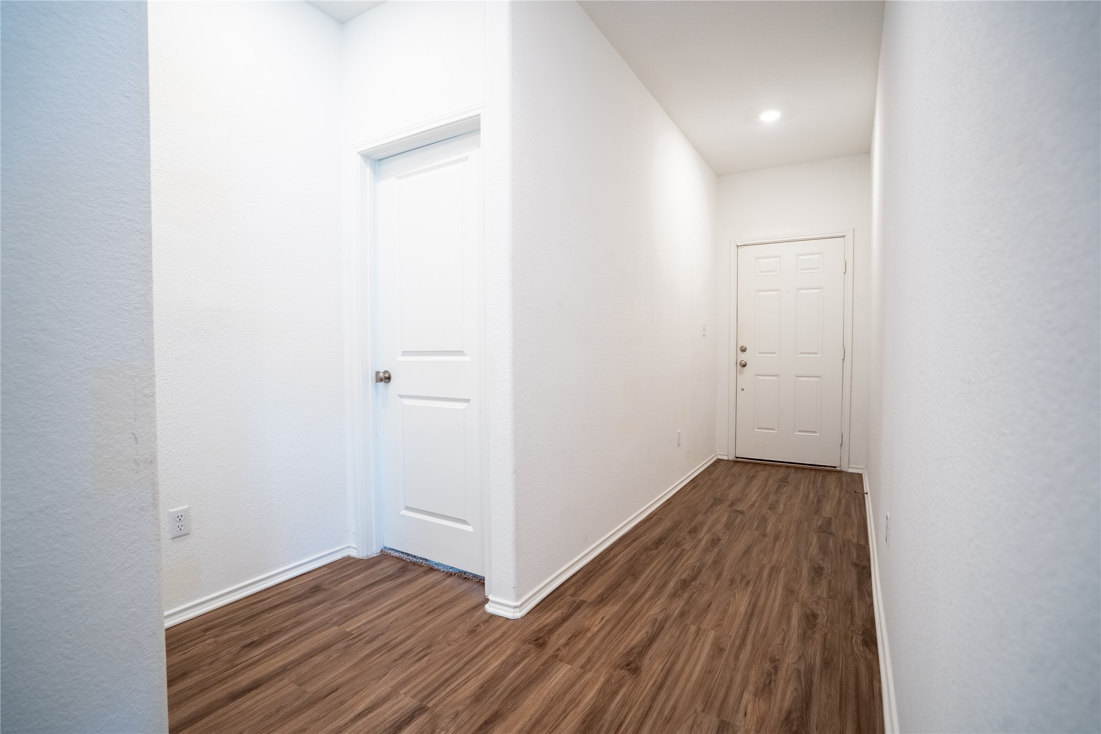 13400 Banquete Street Elgin, TX 78621 - Photo 6 of 29 Corridor featuring dark wood-type flooring and a textured wall