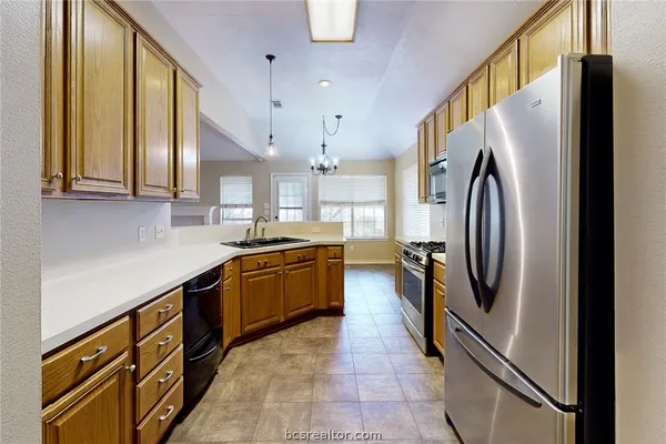 a kitchen with stainless steel appliances granite countertop a refrigerator and a sink