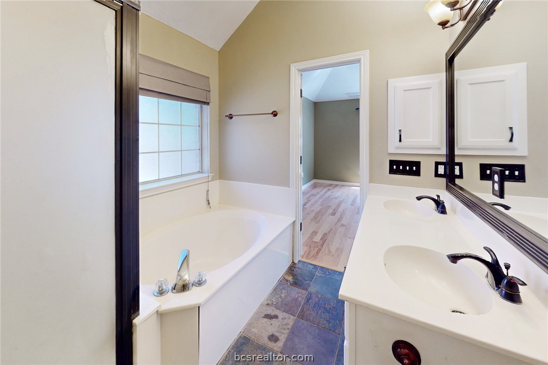 2817 Brandywine Circle Bryan, TX 77807 - Photo 19 of 28 a bathroom with a tub sink and mirror