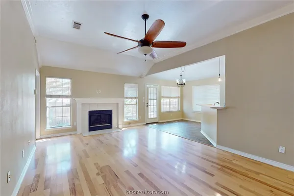 wooden floor fireplace and windows in an empty room