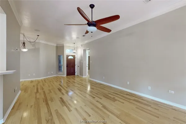 wooden floor in an empty room with a ceiling fan