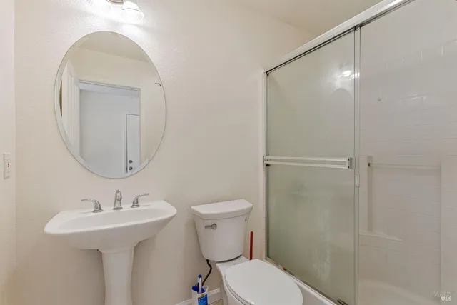 a bathroom with a toilet sink and shower