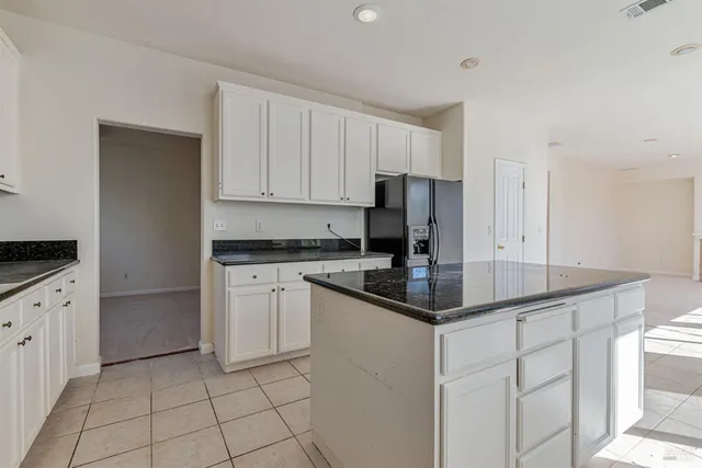 a kitchen with stainless steel appliances granite countertop a sink and a refrigerator