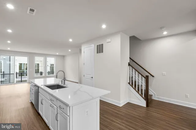 a kitchen with sink stove and wooden floor