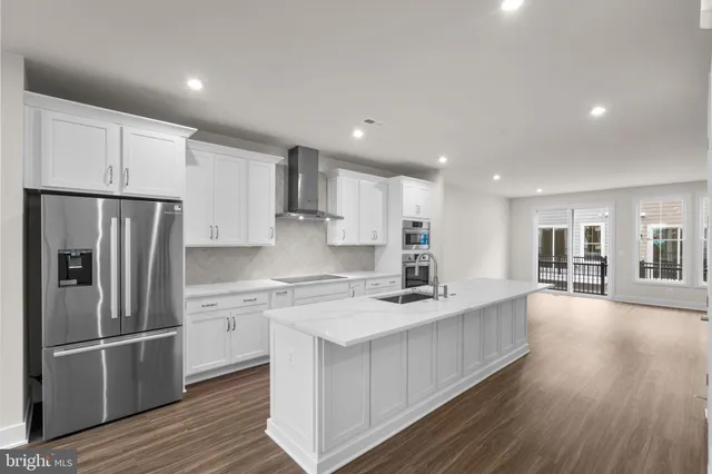 a kitchen with stainless steel appliances granite countertop a refrigerator sink and cabinets