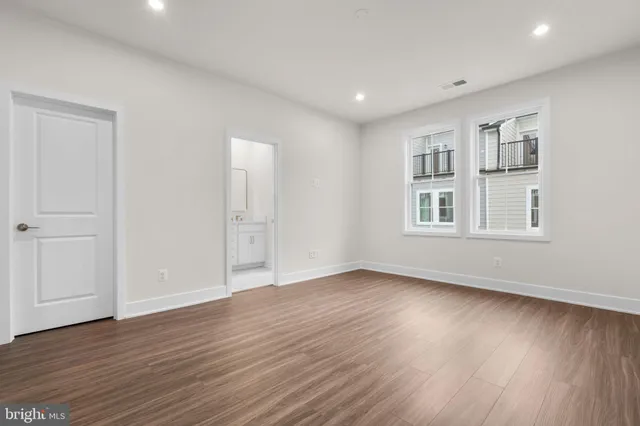 a view of an empty room with wooden floor