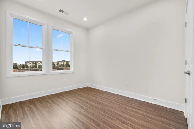 a view of an empty room with wooden floor