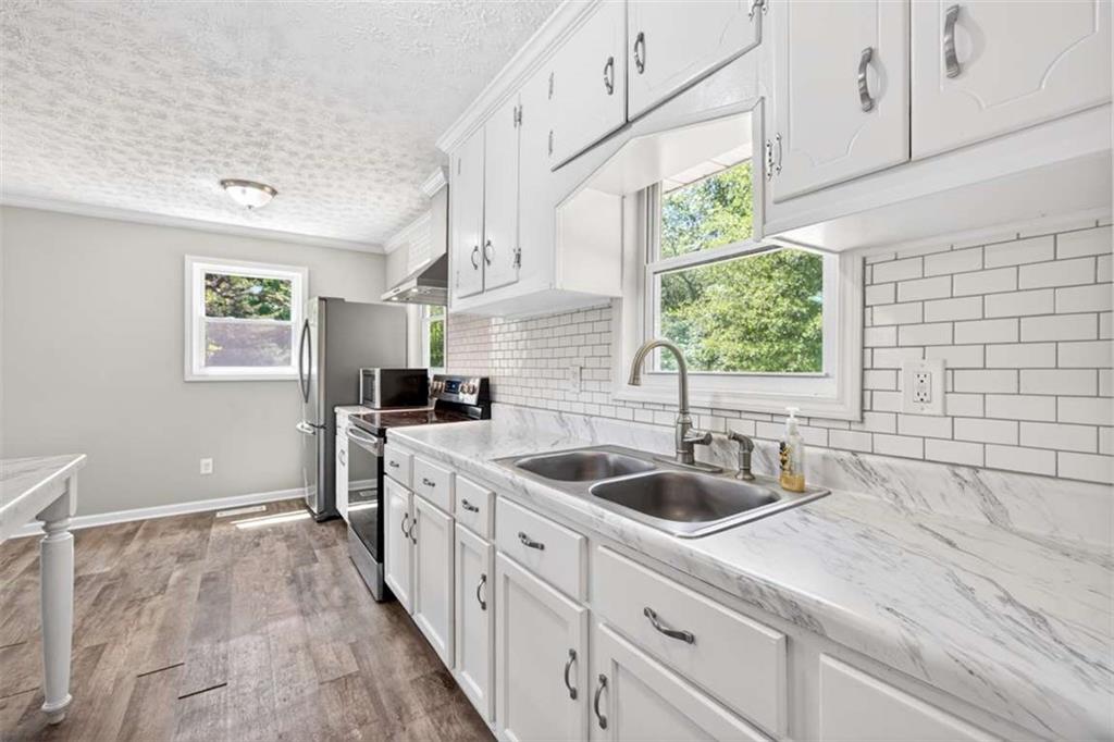 3696 Crabapple Hollow Road Nicholson, GA 30565 - Photo 11 of 38 a kitchen with a sink cabinets a window and stainless steel appliances