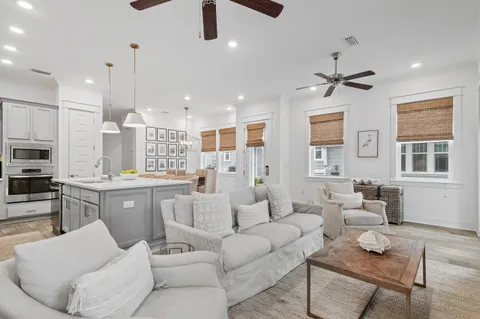 a living room with furniture kitchen view and a window