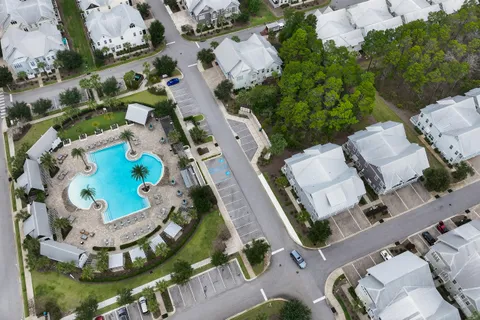 a view of a brick house with large windows and a table and chairs