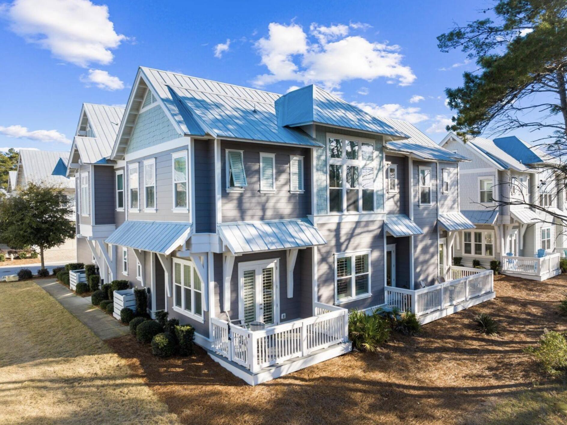 25 Pine Lands Loop East, Unit A Inlet Beach, FL 32461 - Photo 21 of 30 a view of a brick house with large windows and a table and chairs