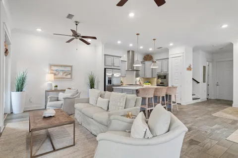 a kitchen with stainless steel appliances granite countertop a dining table chairs refrigerator and cabinets