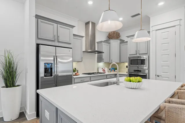 a kitchen with stainless steel appliances granite countertop a sink a stove a refrigerator and island