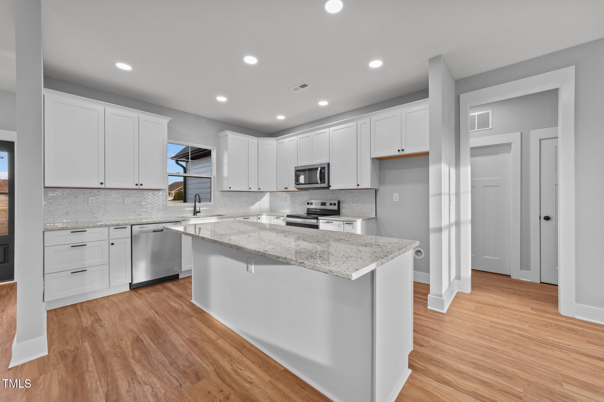2955 Mt Pleasant Road Willow Spring, NC 27592 - Photo 12 of 44 a kitchen with stainless steel appliances granite countertop a sink stove and refrigerator