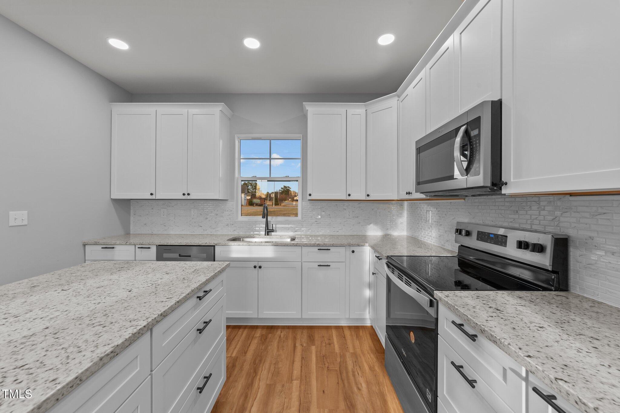 2955 Mt Pleasant Road Willow Spring, NC 27592 - Photo 14 of 44 a kitchen with a sink stove top oven and cabinets