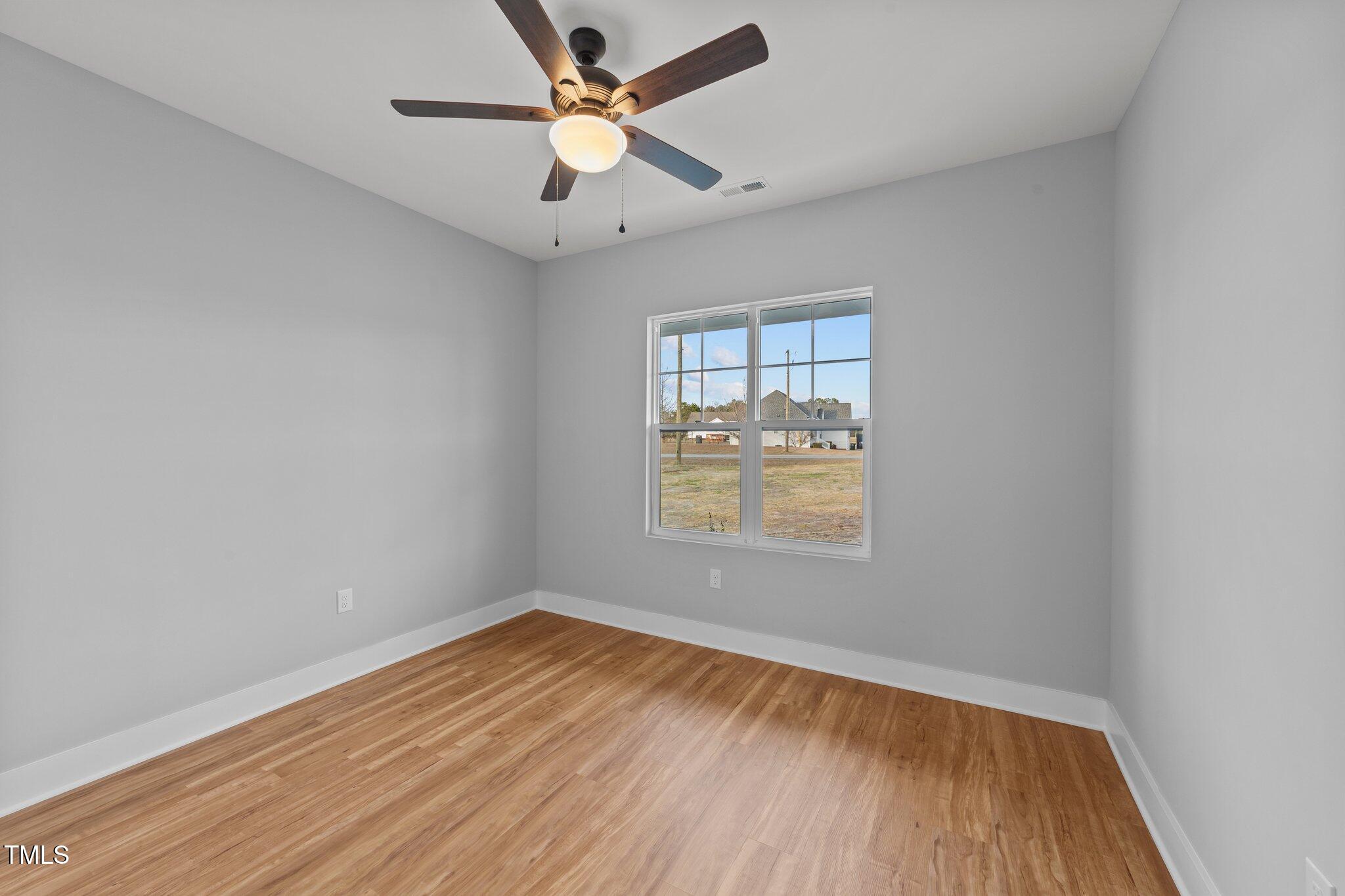 2955 Mt Pleasant Road Willow Spring, NC 27592 - Photo 16 of 44 an empty room with wooden floor and windows