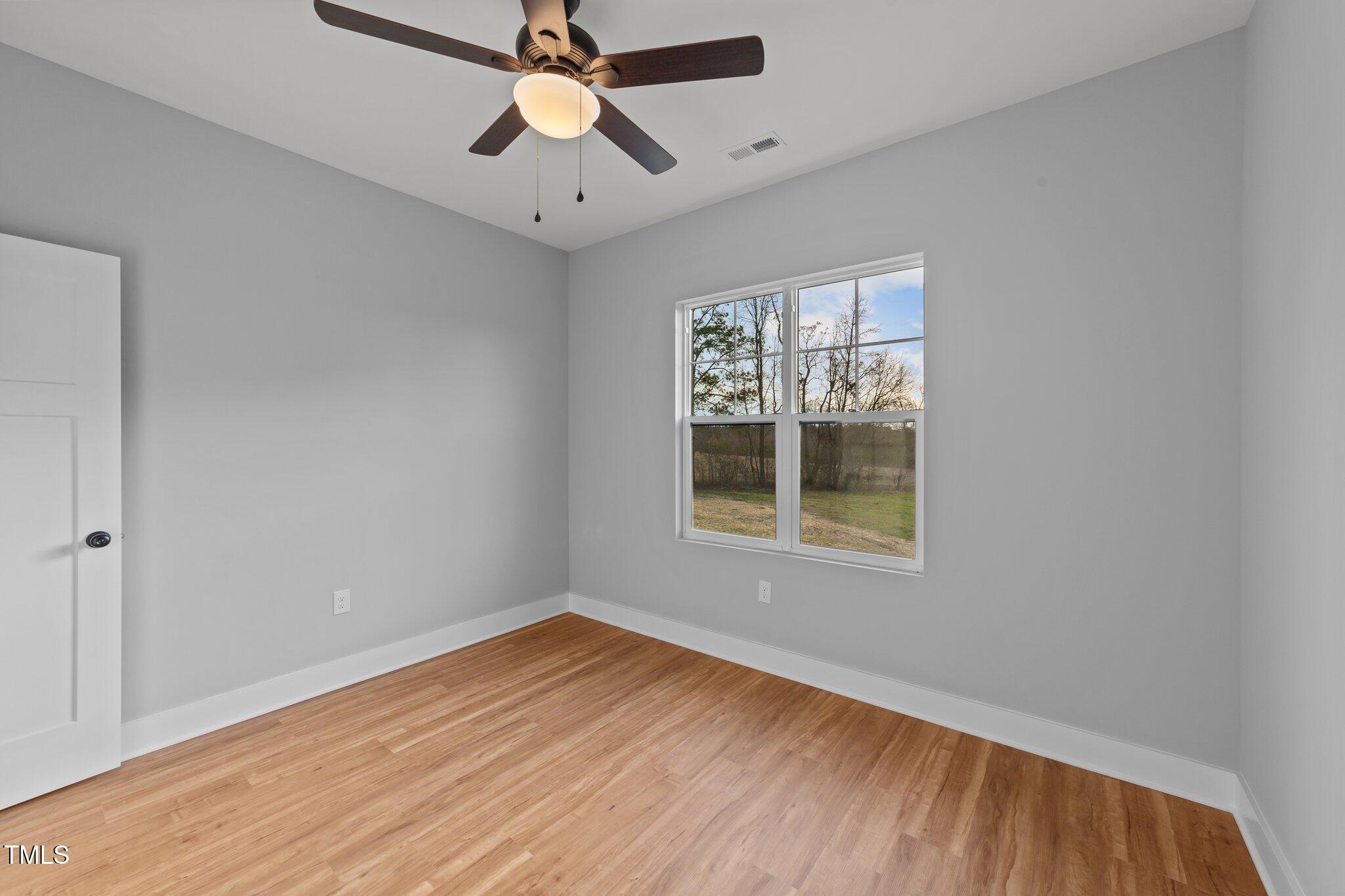 2955 Mt Pleasant Road Willow Spring, NC 27592 - Photo 20 of 44 wooden floor in an empty room with a window