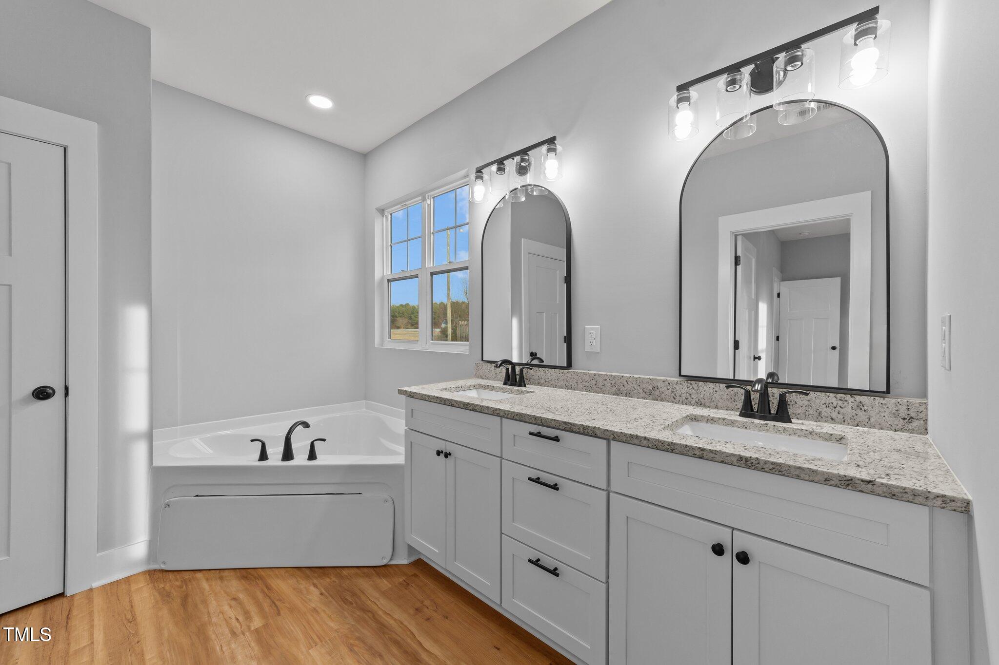 2955 Mt Pleasant Road Willow Spring, NC 27592 - Photo 27 of 44 a spacious bathroom with a granite countertop sink mirror and bathtub