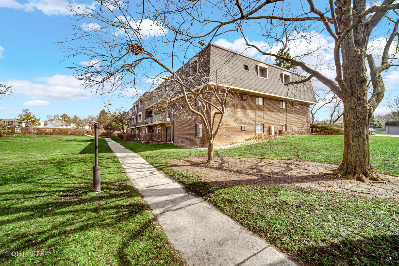 258 East Bailey Road, Unit J Naperville, IL 60565 - Photo 21 of 22 a view of a white house with a yard and a large tree