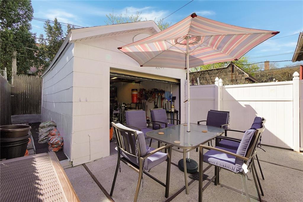 2318 Knapp Street Brooklyn, NY 11229 - Photo 26 of 32 a view of a patio with a dining table and chairs under an umbrella