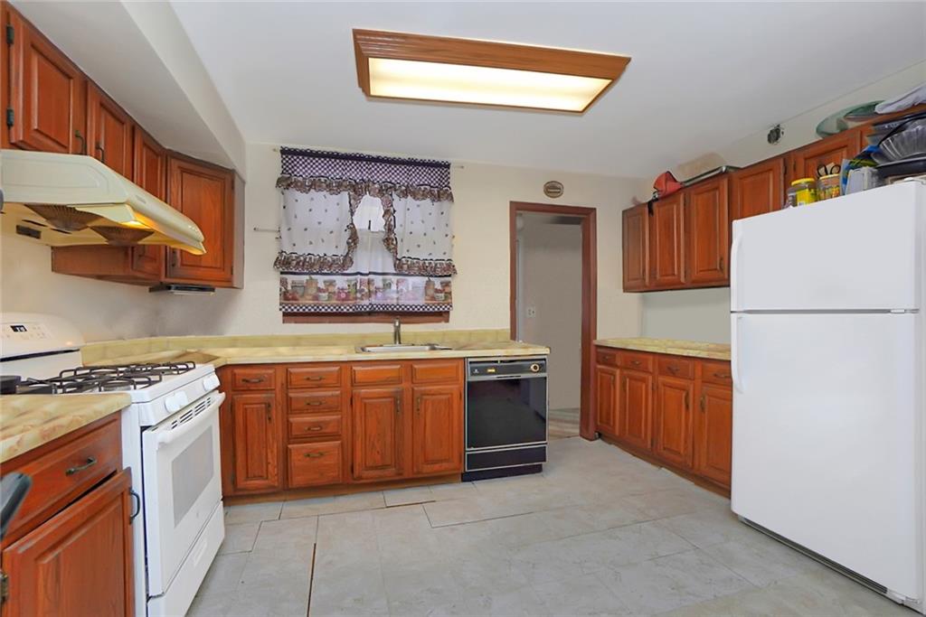 2318 Knapp Street Brooklyn, NY 11229 - Photo 8 of 32 a kitchen with stainless steel appliances granite countertop a stove a sink and a refrigerator
