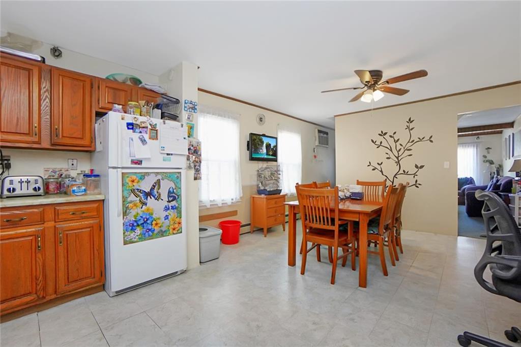2318 Knapp Street Brooklyn, NY 11229 - Photo 10 of 32 a dining area with furniture a chandelier and a refrigerator