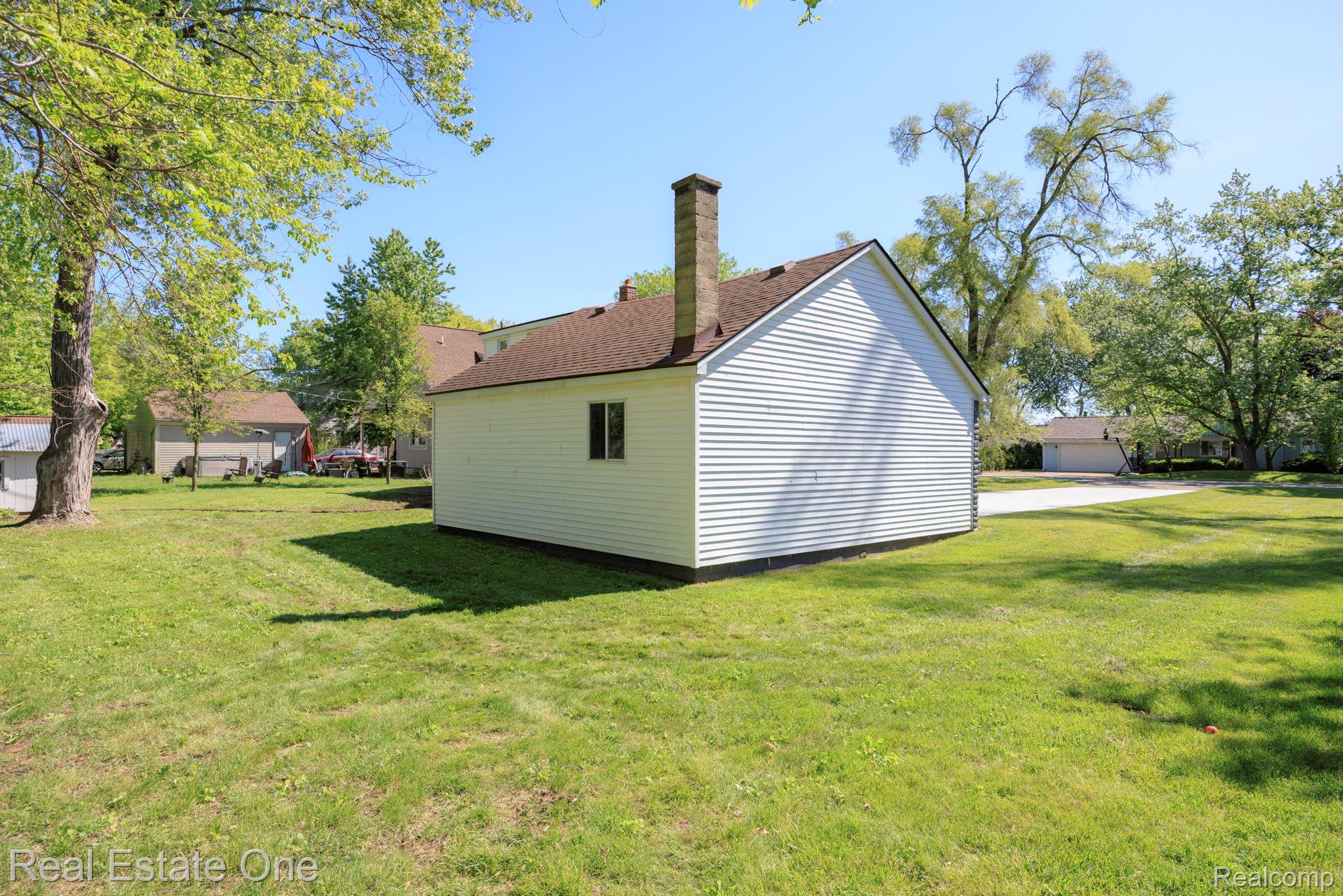3200 Hessel Avenue Rochester, MI 48307 - Photo 30 of 32 View of property exterior with a lawn and a chimney