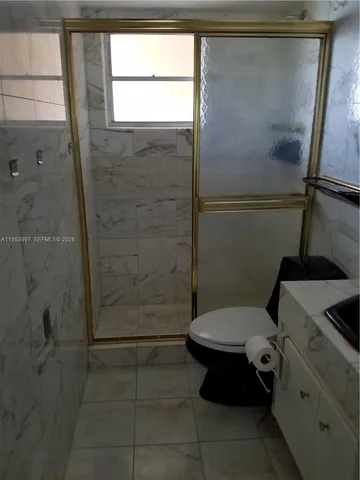 a bathroom with a toilet and a shower