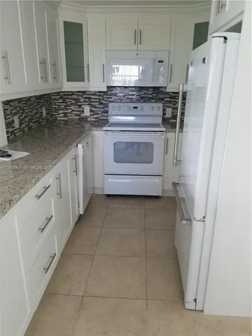 a kitchen with a refrigerator sink and cabinets