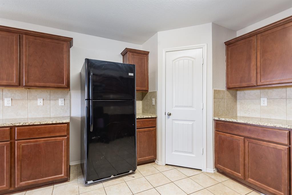 1025 Bend Court Forney, TX 75126 - Photo 6 of 12 a kitchen with a refrigerator and cabinets