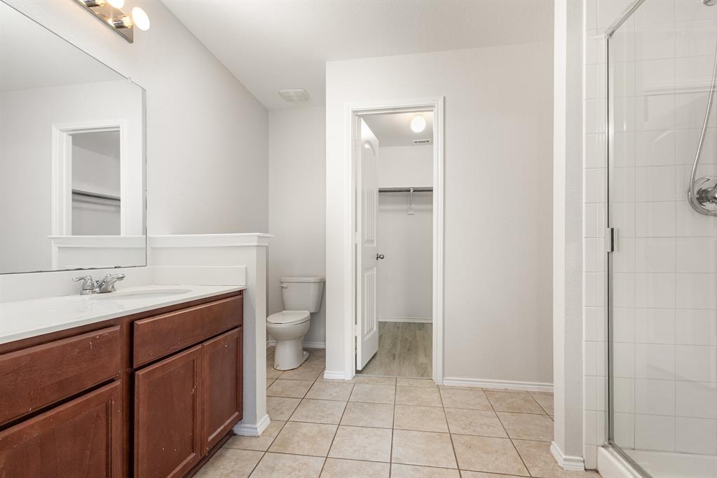 1025 Bend Court Forney, TX 75126 - Photo 8 of 12 a spacious bathroom with a toilet sink and mirror