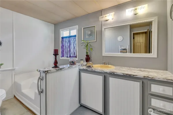 a bathroom with a granite countertop sink and a mirror