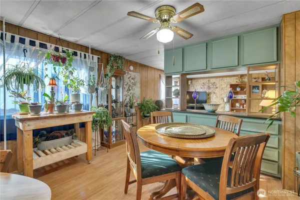 a dining room with furniture a floor to ceiling window and wooden floor