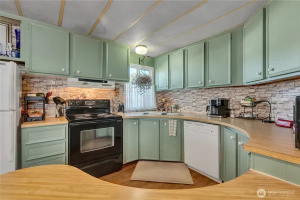 a kitchen with stainless steel appliances granite countertop a stove a sink and a microwave
