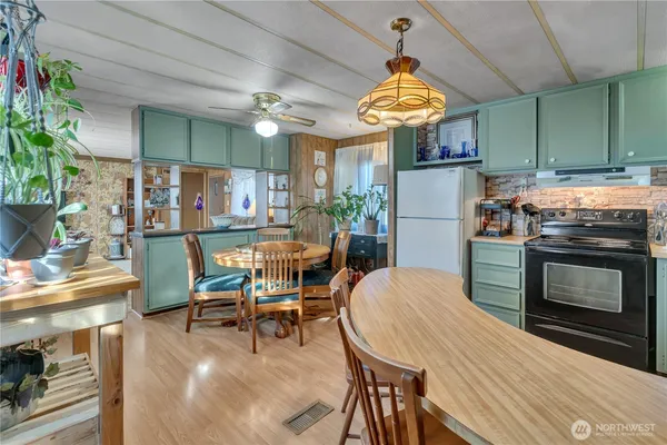 a kitchen with stainless steel appliances a dining table chairs stove and kitchen view