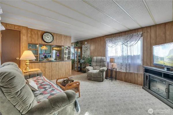 a living room with furniture a large window and wooden floors