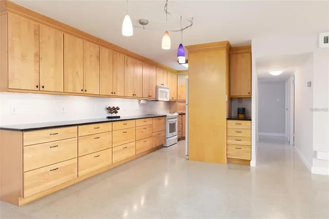 a kitchen with granite countertop cabinets and refrigerator