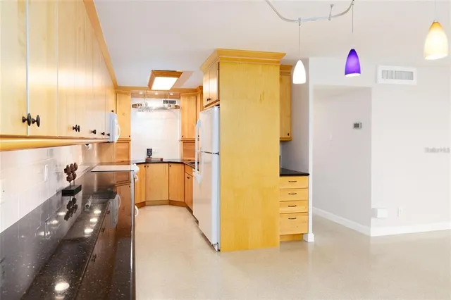 a view of a kitchen with a refrigerator and a more cabinets